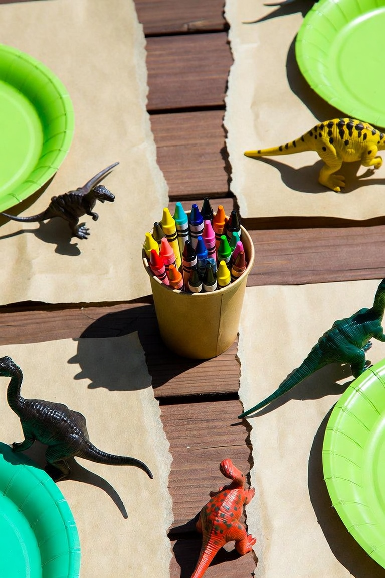 Kraft paper runner on a wooden table with green plates and toy figurines