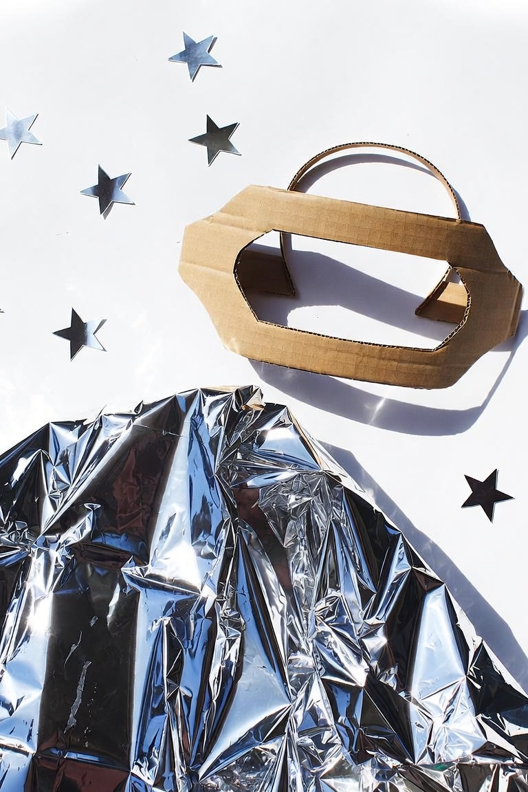 DIY foil space cape and cardboard helmet band decorated with stars