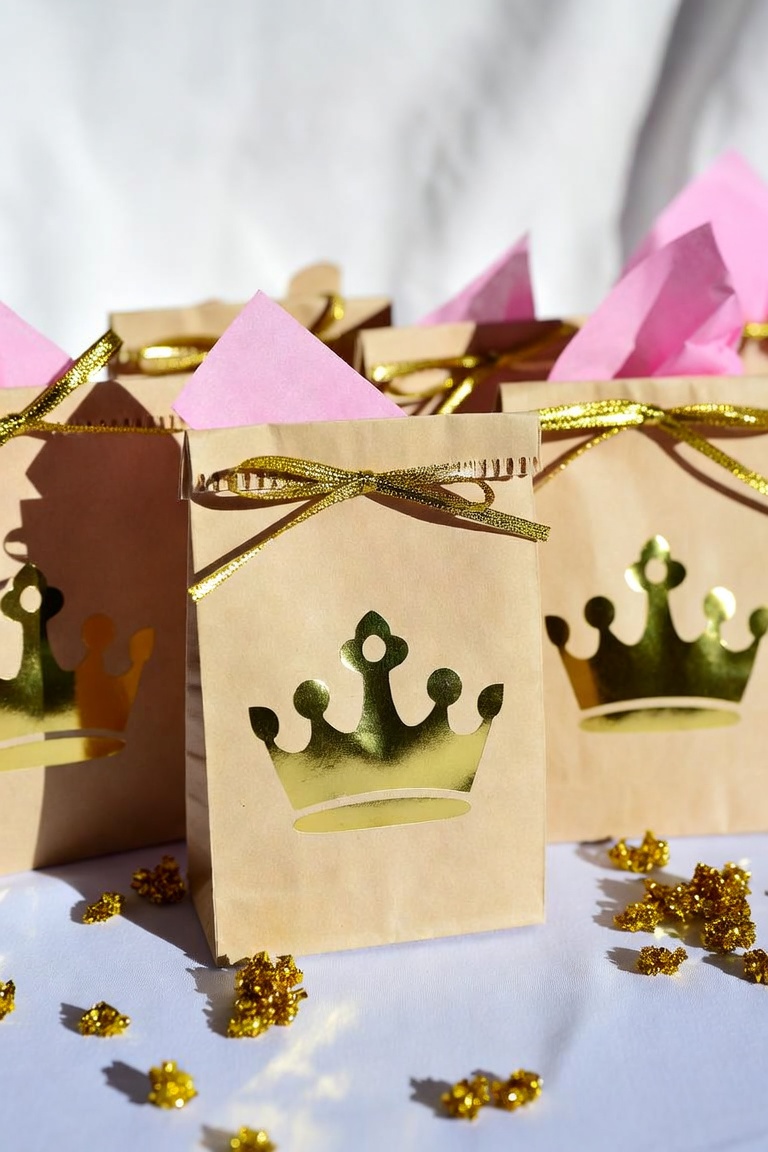 DIY gold crown paper party favor bags with pink tissue paper and gold ribbon